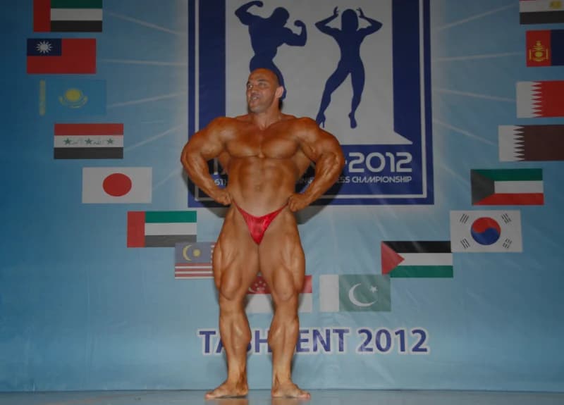 Bodybuilder poses on stage at competition