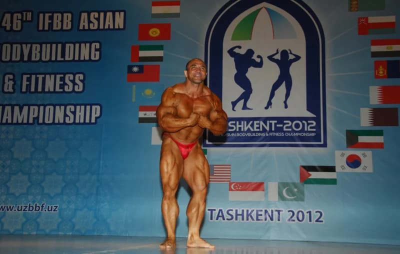 Bodybuilder posing on stage at a fitness championship