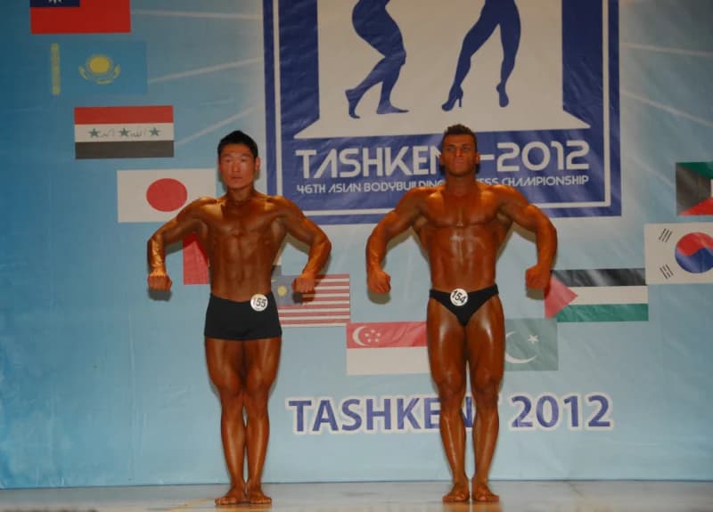 Bodybuilders pose on stage during competition