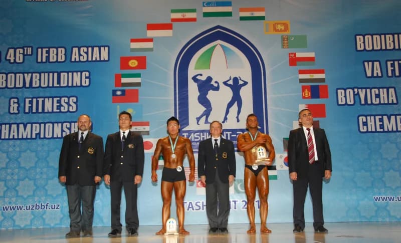 Athletes and officials pose on stage during a bodybuilding championship