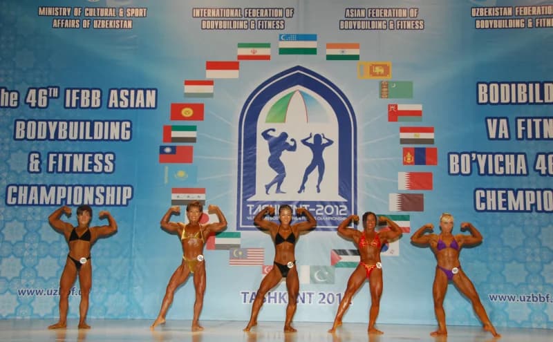 Athletes pose on stage during bodybuilding competition