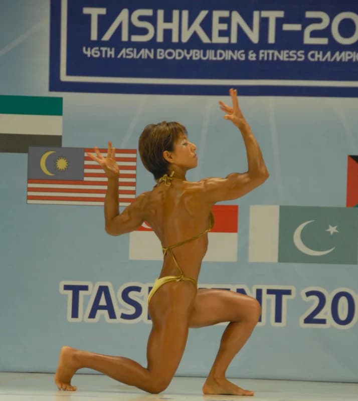 Athlete poses on stage during competition