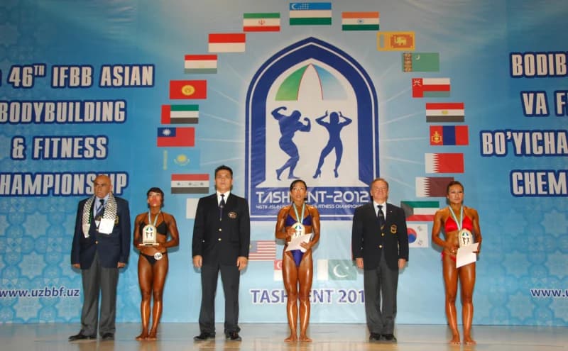 Спортсмены и официальные лица позируют на сцене на спортивных соревнованиях.