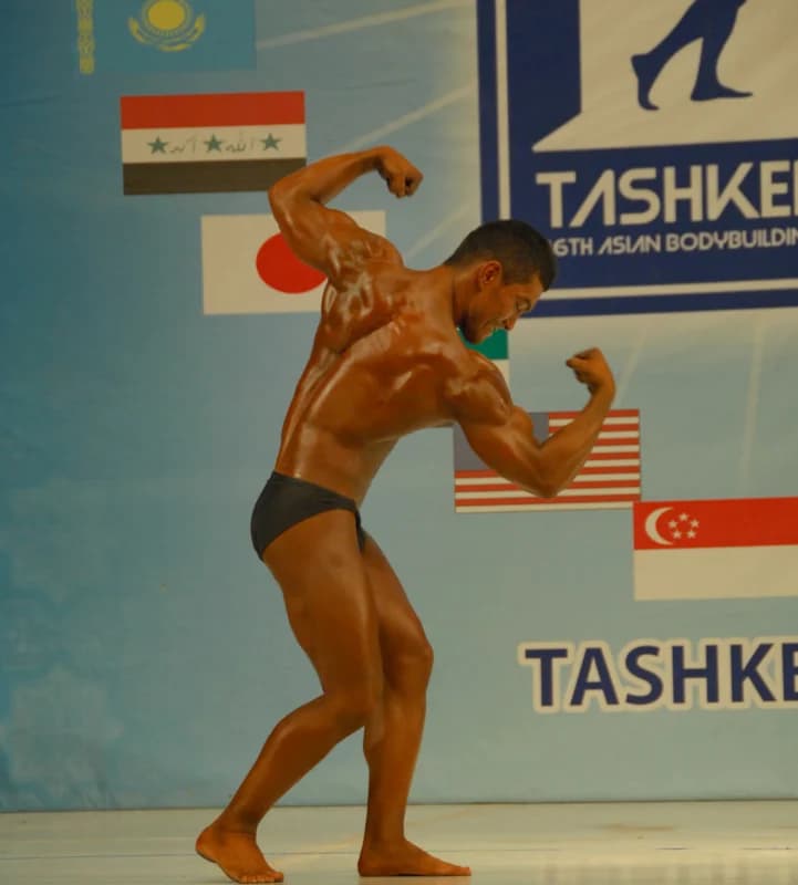 Bodybuilder performs a pose on stage during a competition