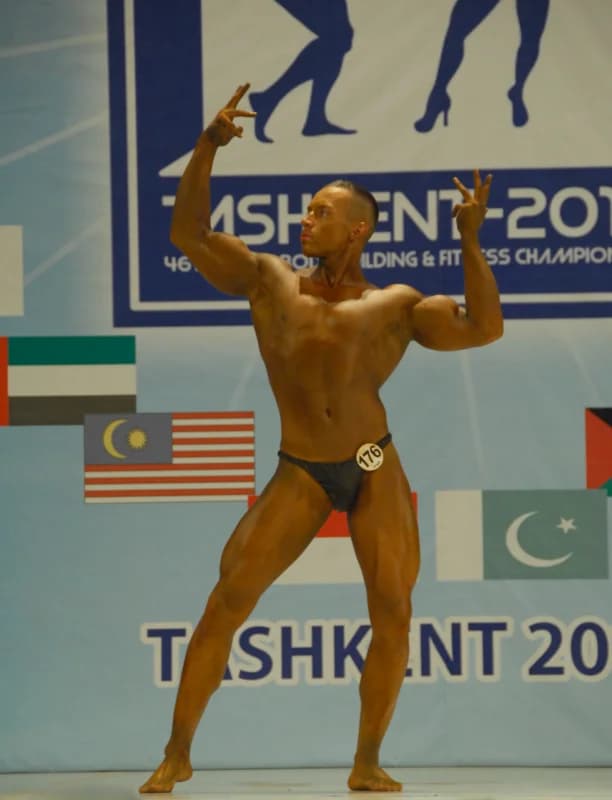 Athlete poses on stage during competition