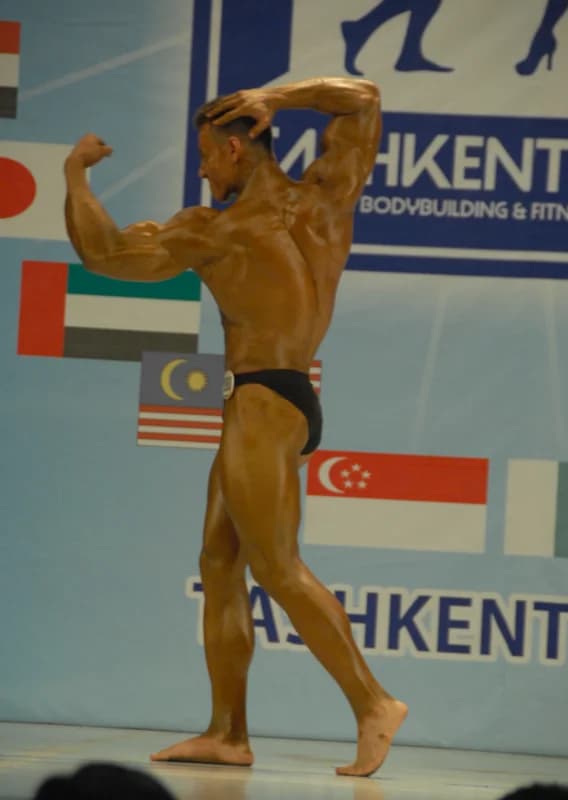 Athlete poses on stage during a competition
