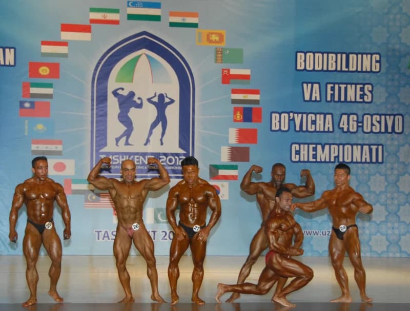 Бодибилдеры позируют на сцене во время соревнований