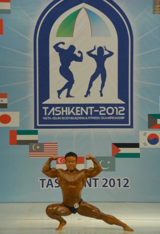 Athlete poses on stage during a bodybuilding event
