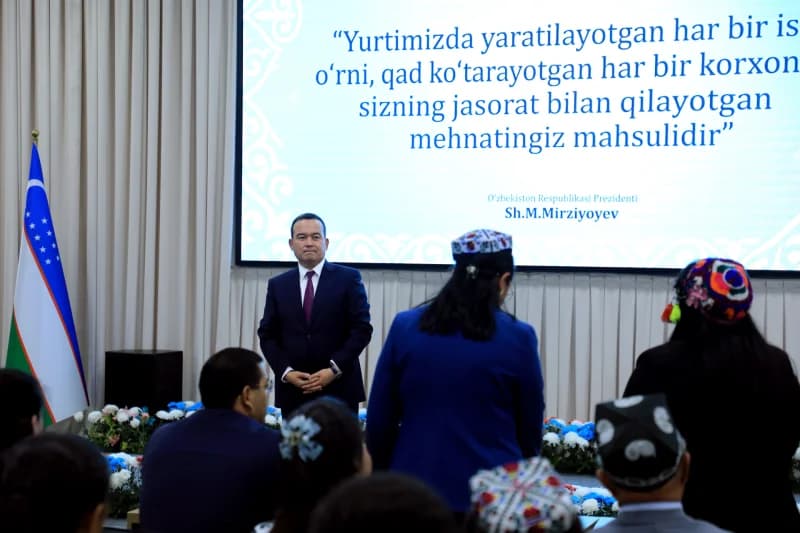 Man in suit addressing an audience in a hall