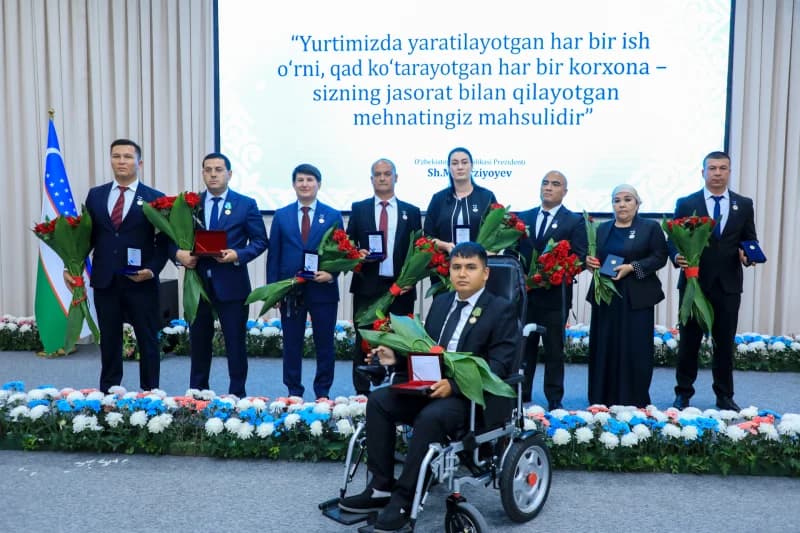 Group portrait of people holding awards and flowers