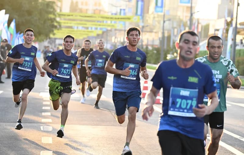 Спортсмены, бегущие в уличной гонке