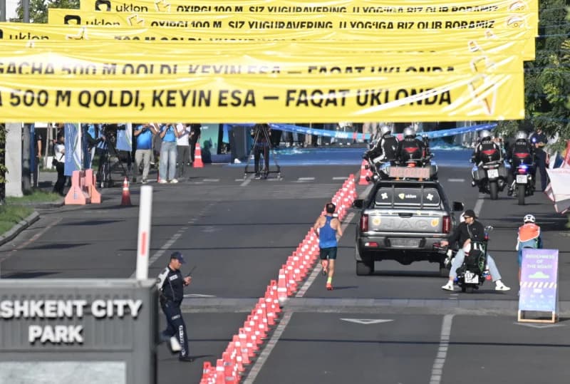 Спортсмен, бегущий по улице города во время соревнований