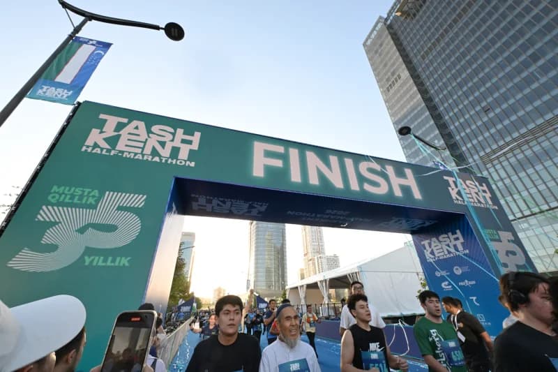 People running past a finish line arch