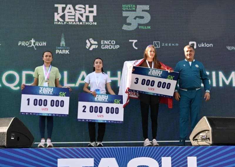 Спортсмены, стоящие на подиуме и держащие призовые чеки