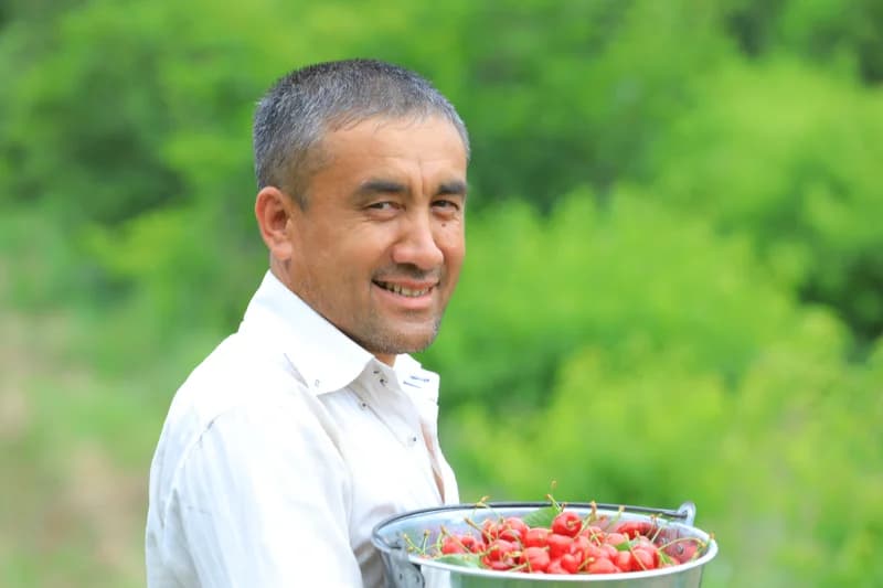 Man holding bucket of cherries