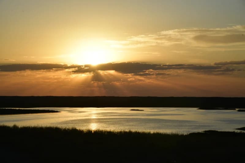 Sunset over a lake with dramatic clouds and glowing reflections
