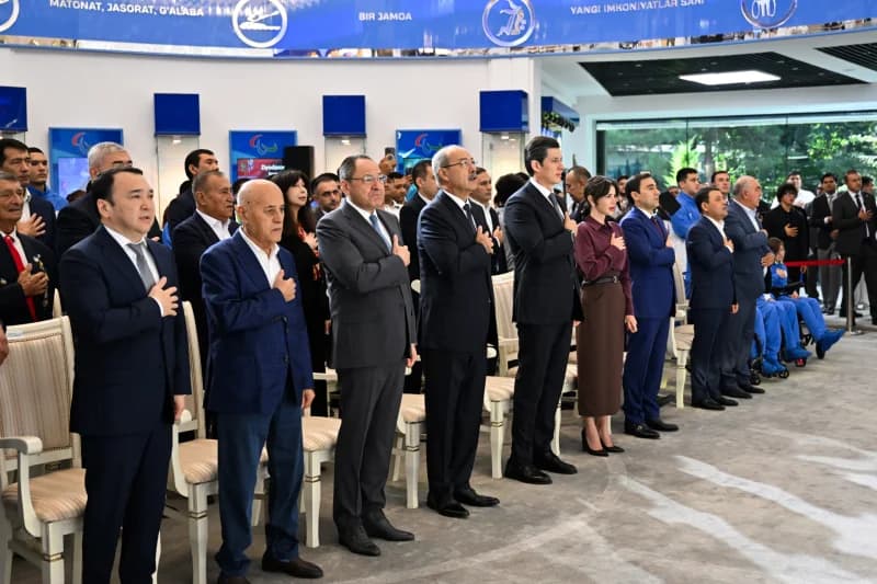 Adham Ikramov and other people standing indoors