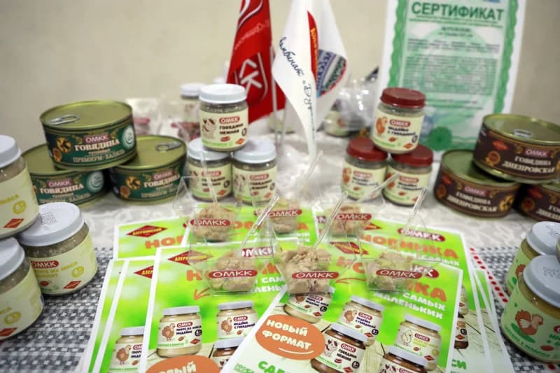 Ассортимент консервированных продуктов и образцы, выставленные на столе.
