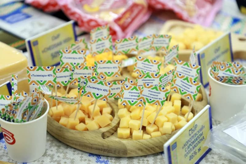 Assorted cheese samples on wooden platters with small identifying flags
