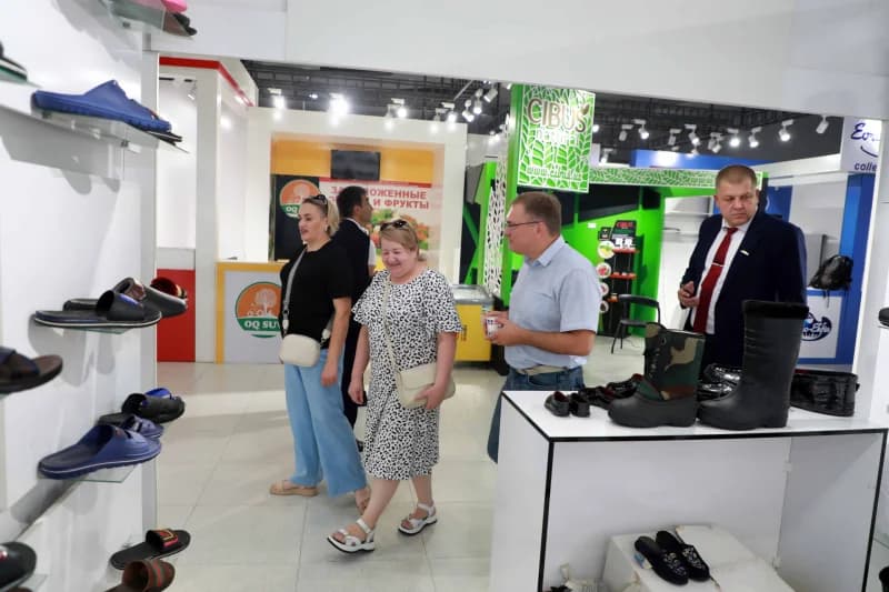 People inspecting footwear displays inside a trade exhibition hall