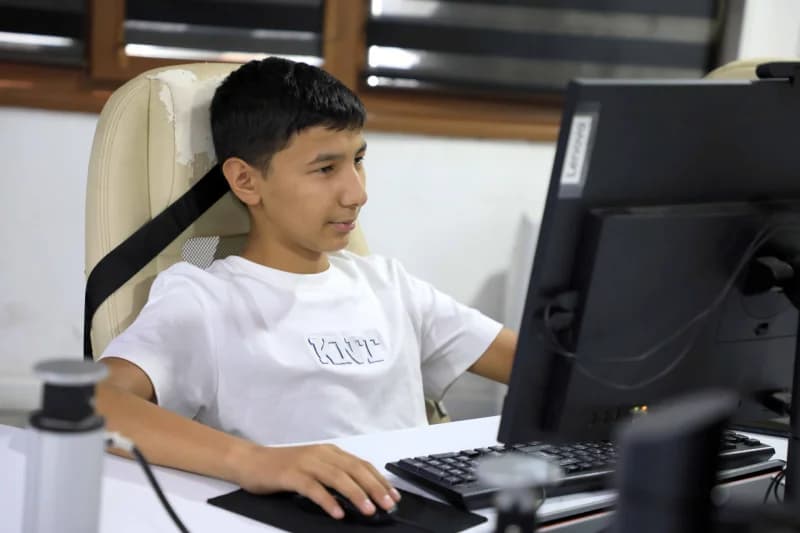 Молодой человек, использующий компьютер за столом