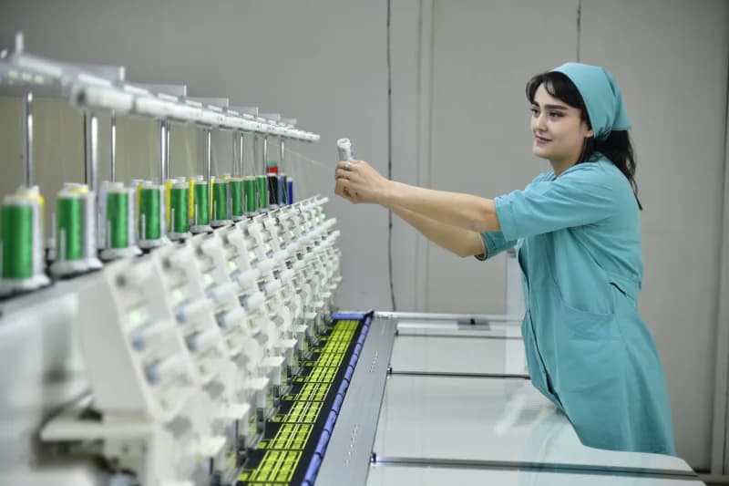 Woman working with industrial embroidery machine