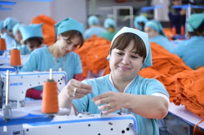 Garment factory workers operating sewing machines