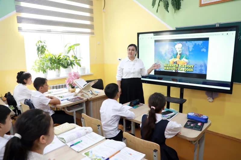 Учитель, ведущий урок в классе с цифровым дисплеем