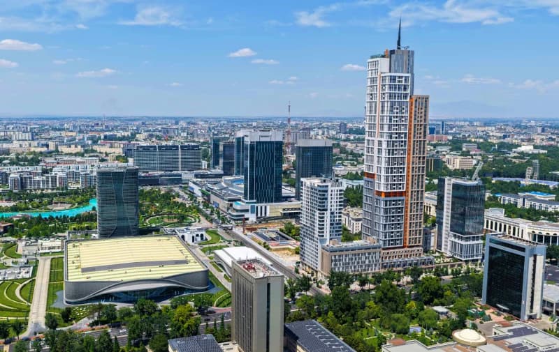 Aerial view of a modern urban skyline with skyscrapers and green spaces