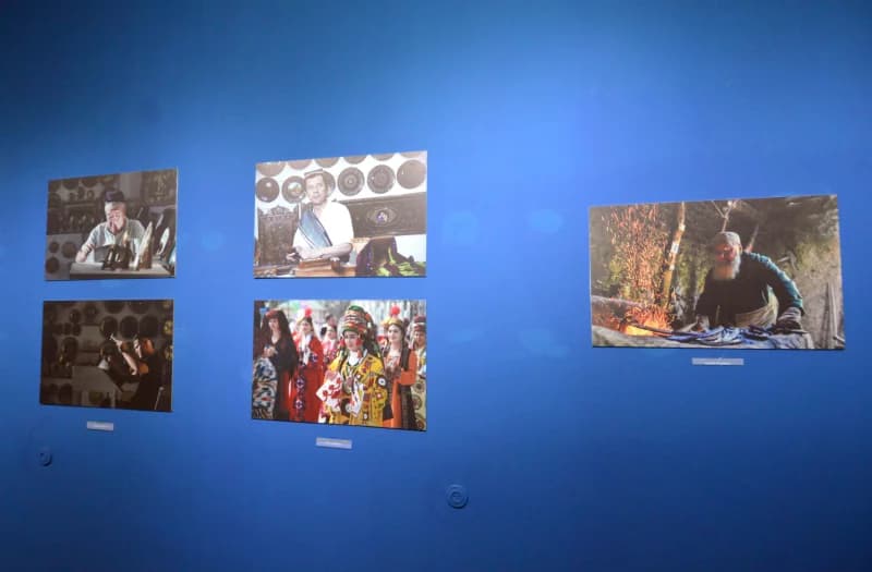 Фотографии, выставленные на голубой стене на выставке