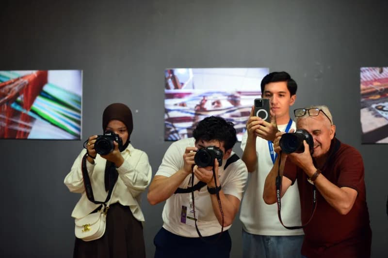 People taking photos in an indoor gallery setting
