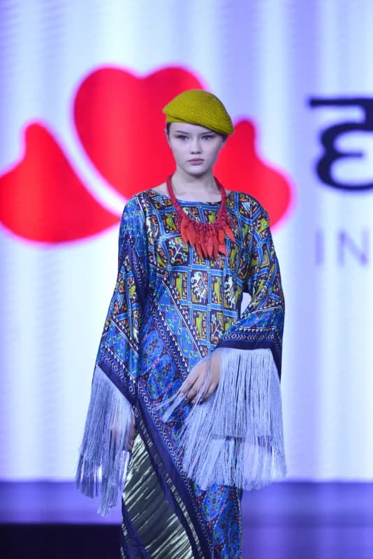 Model posing in patterned clothing during a fashion presentation