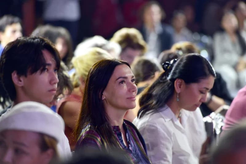 People seated in an audience watching an event