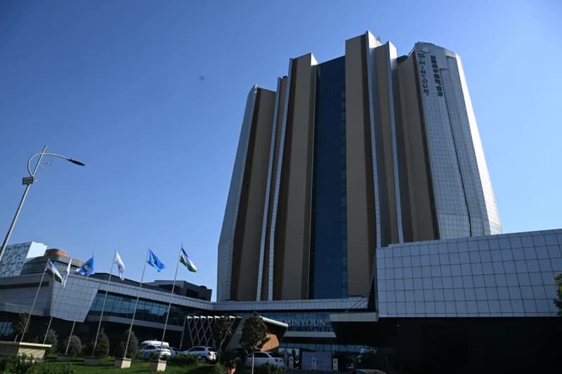 Modern high-rise building with flags and clear blue sky