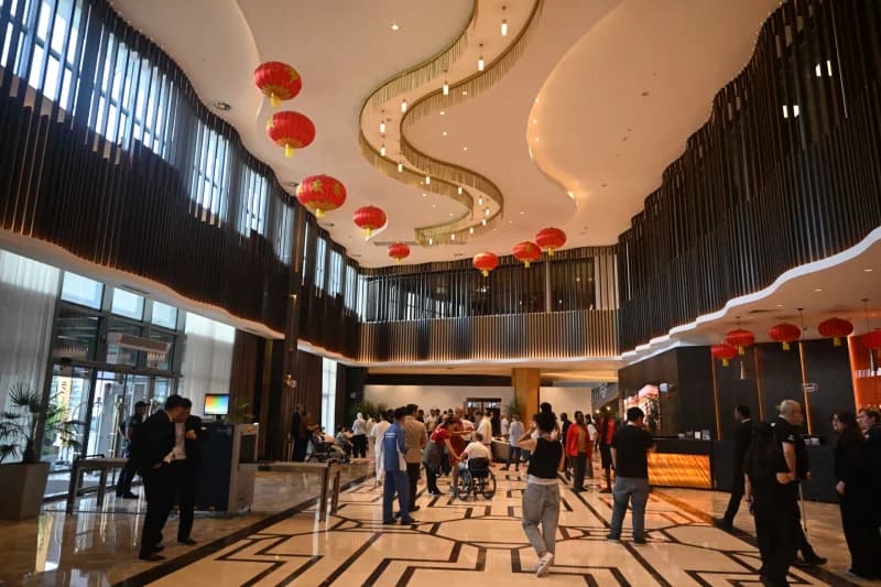 People gathered in a modern hotel lobby decorated with red lanterns