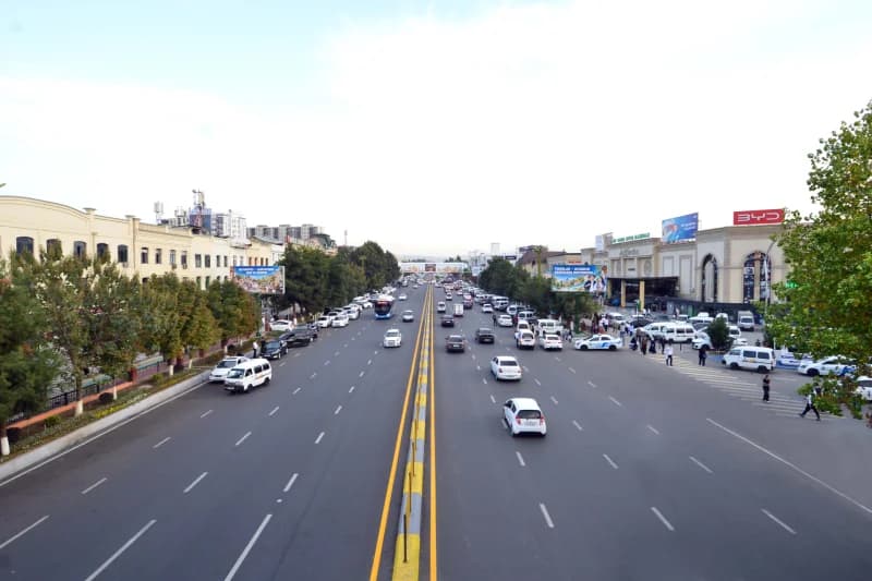 Busy multi-lane city avenue with moving traffic and roadside buildings