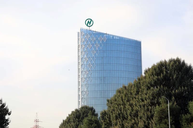 Modern high-rise commercial building exterior with glass facade and geometric decoration