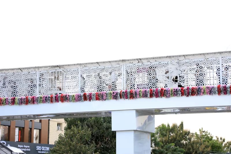 White pedestrian overpass decorated with floral arrangements