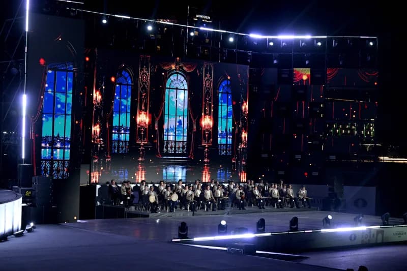 Orchestra performing on illuminated stage at night