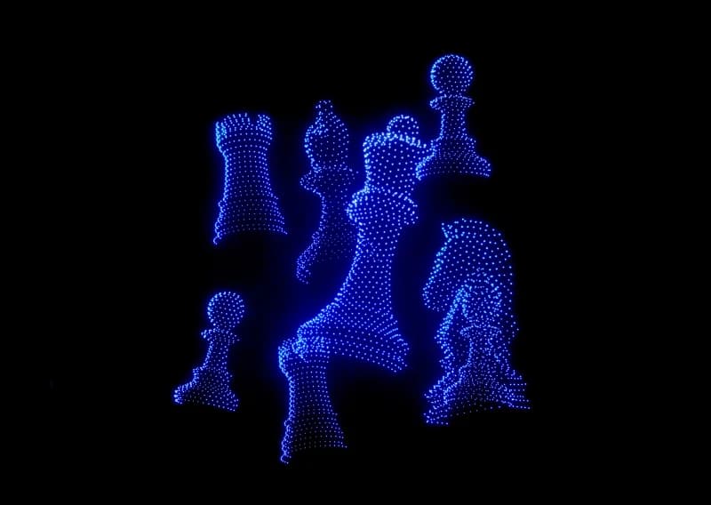 Освещенные шахматные фигуры, созданные ярко-синими огнями на темном фоне