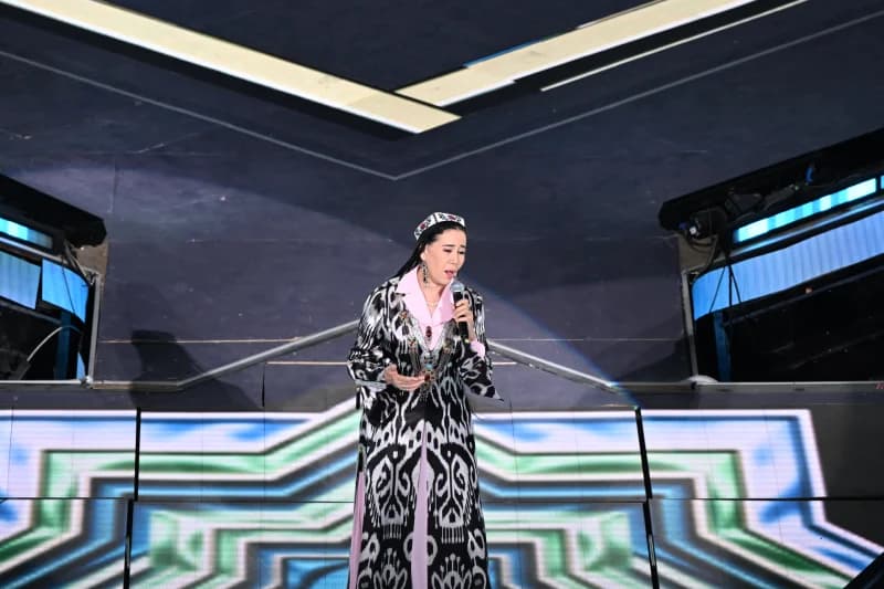 Woman singing into a microphone on stage