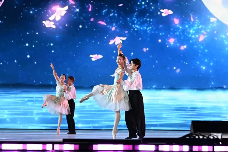 Ballet dancers perform on stage with a digital backdrop