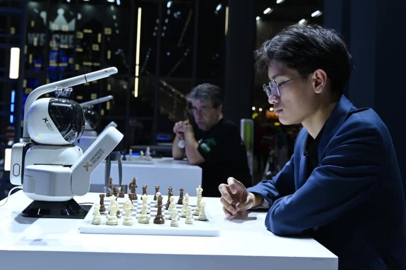 Person playing chess against a robotic arm