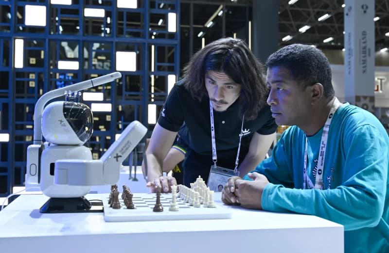 People playing chess with a robotic arm