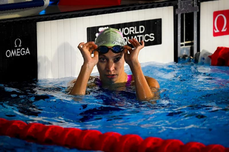 Swimmer adjusts goggles in a pool
