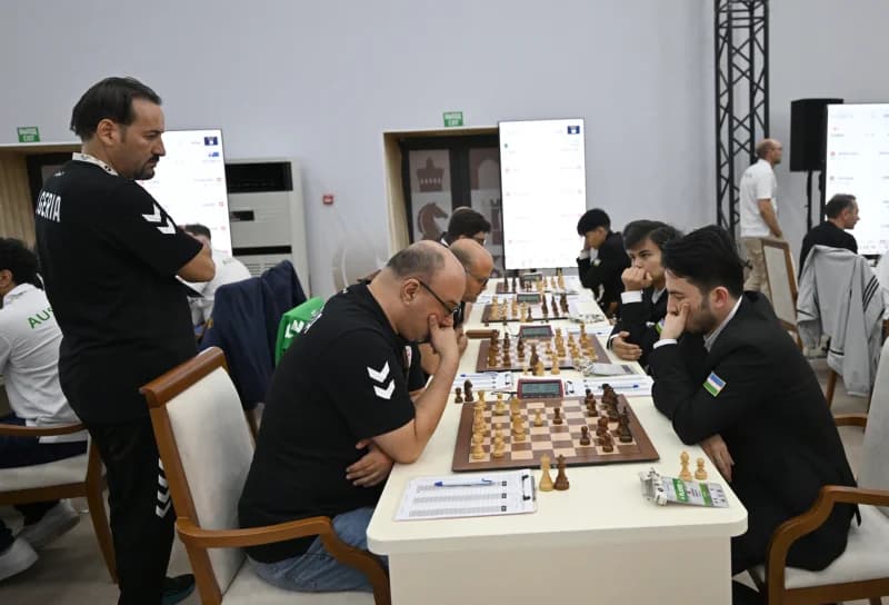 People playing chess at tables in a room