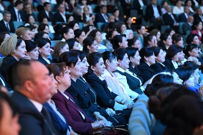 Audience members seated in an indoor auditorium