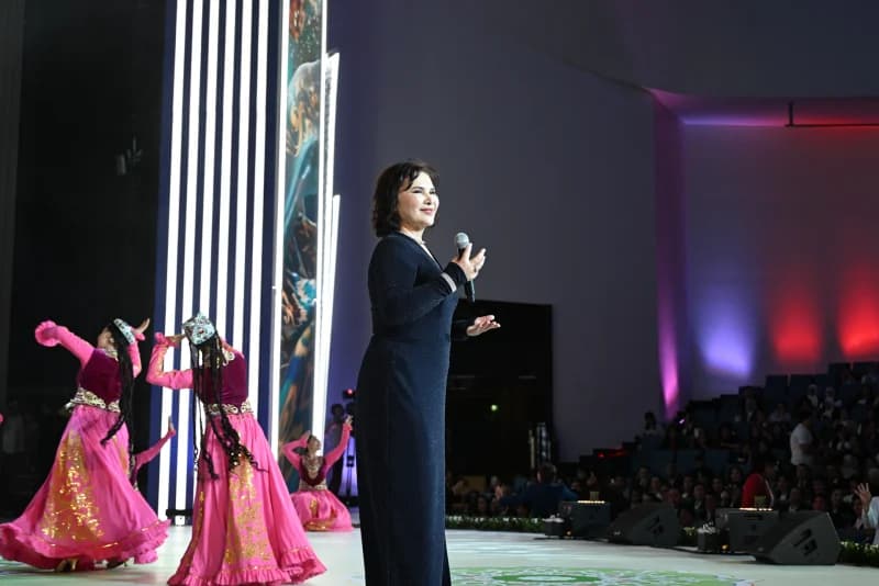 Woman speaking into a microphone on stage during an event