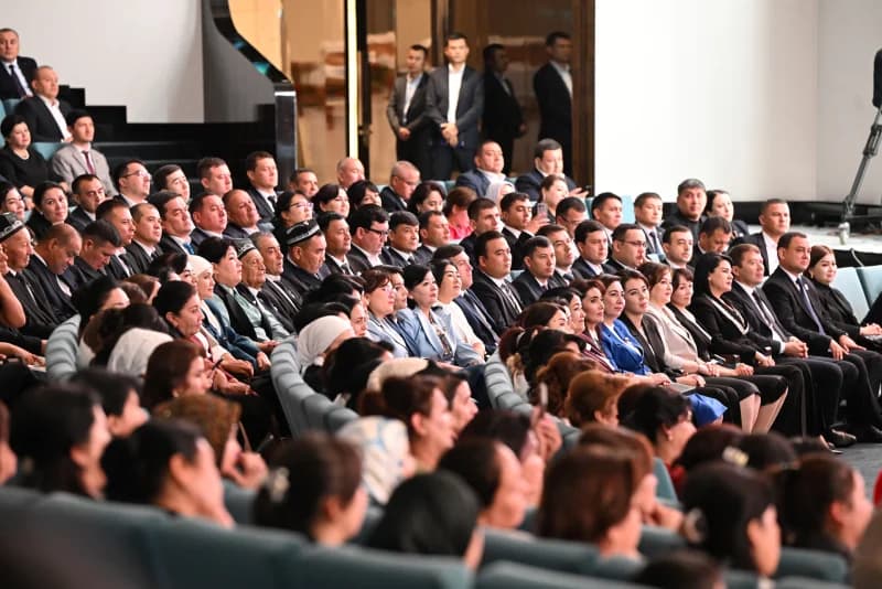 Large audience sitting in an indoor auditorium