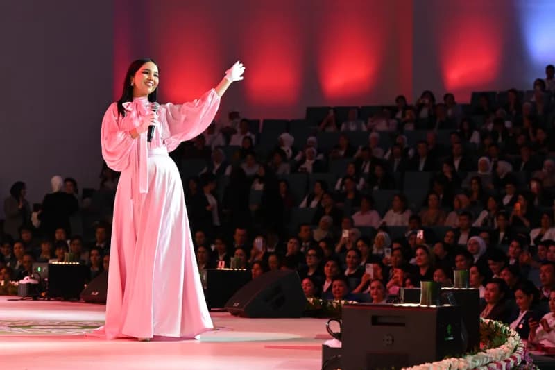 A performer on stage holding a microphone in front of an audience